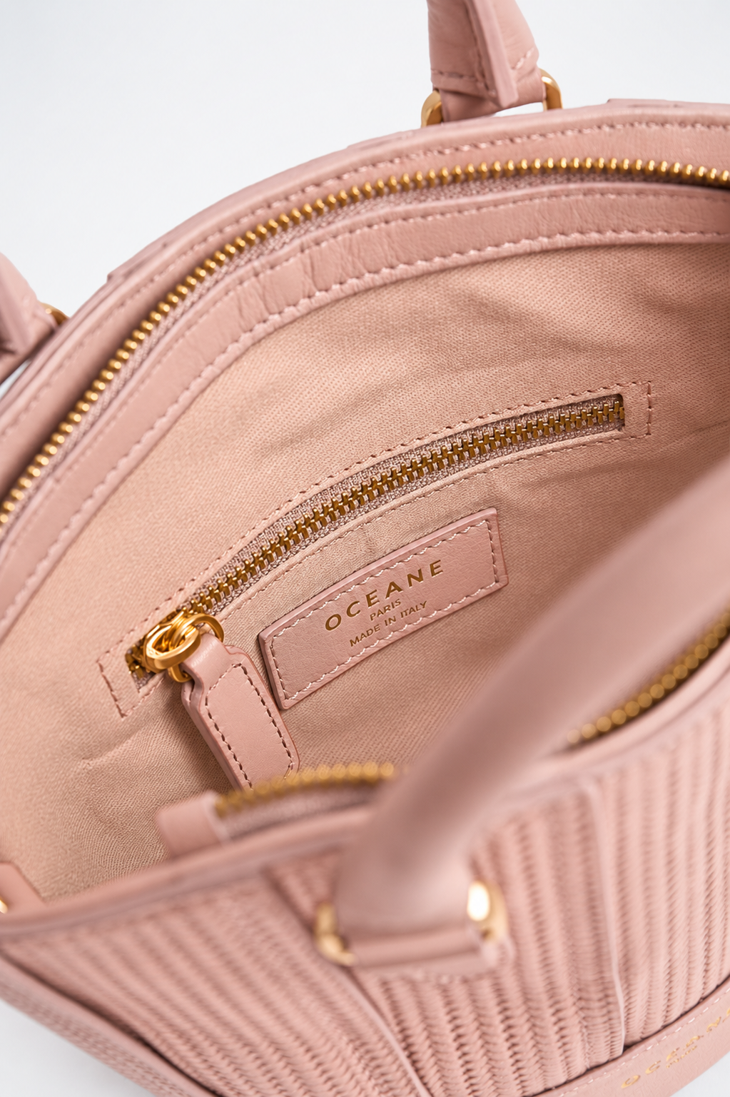 Interno della Jade Bag rosa cipria di Oceane Paris, con tasca con zip e targhetta del marchio Made in Italy.
