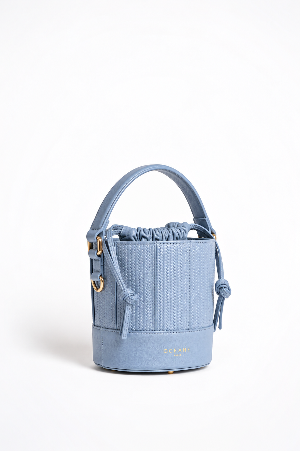 Grace Bucket azzurra di Oceane Paris, vista di tre quarti con manico in pelle e chiusura a coulisse.